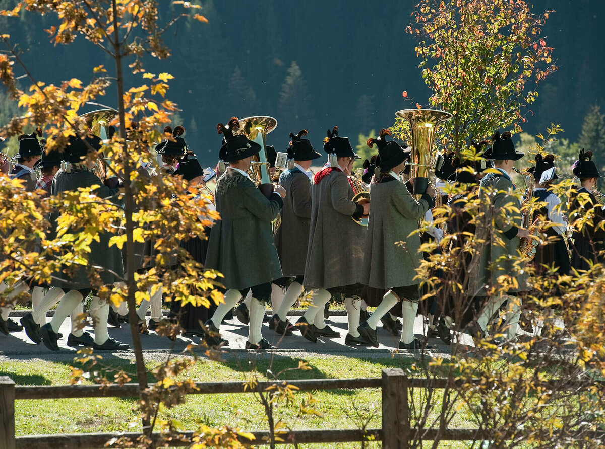 Fest im Herbst Zwischen zwei verfärbten Bäume sieht man Häuser eines Dorfes.