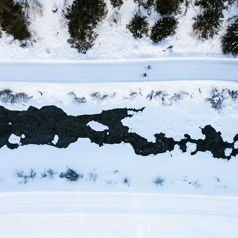 Langlaufen in Prägraten Blick auf die Langlaufloipe in Prägraten aus der Vogelperspektive mit dem daneben vorbeilaufenden Bach.