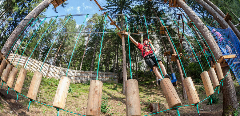 Hochseilgartengalitzenklamm 2 Junger Bub hantelt sich geschickt durch eine Station im Hochseilgarten Galitzenklamm