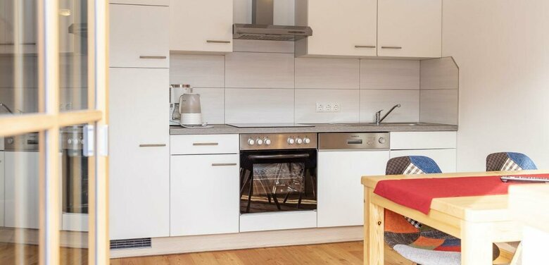 Küchenblock in einer Ferienwohnung mit Holzboden und einem Esstisch vom Balkon aus