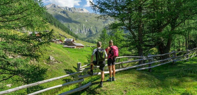 Weitwandern auf der Glocknerkrone in Osttirol, Etappe 1. Zwei Wanderer genießen den Blick auf die Äußere Steiner Alm.