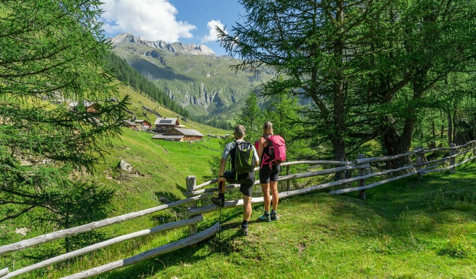 Blick auf die äußere Steiner Alm Weitwandern auf der Glocknerkrone in Osttirol, Etappe 1. Zwei Wanderer genießen den Blick auf die Äußere Steiner Alm.