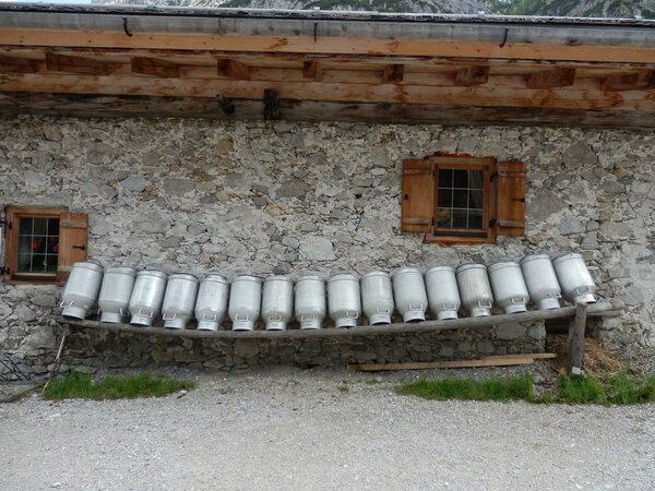 Milchkandeln hängen aufgereiht vor den Steinmauern des Rieplerhofs. 