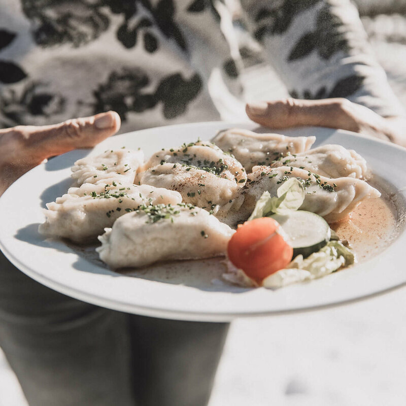 Osstiroler Schlipfkrapfen mit Schnittlauch und geschmolzener Butter und einem kleinen gemischten Salat.