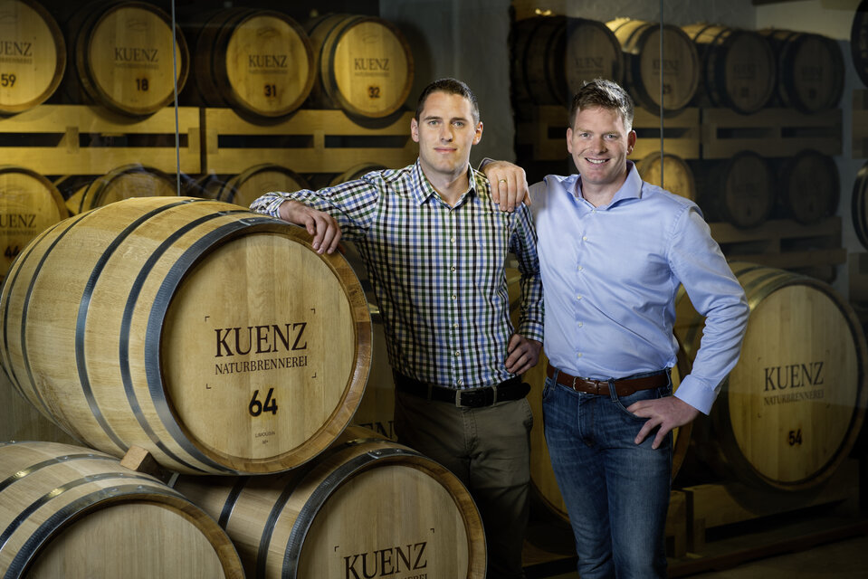 Die beiden Brüder Kuenz vor den Schnapsfässern in ihrer Brennerei.
