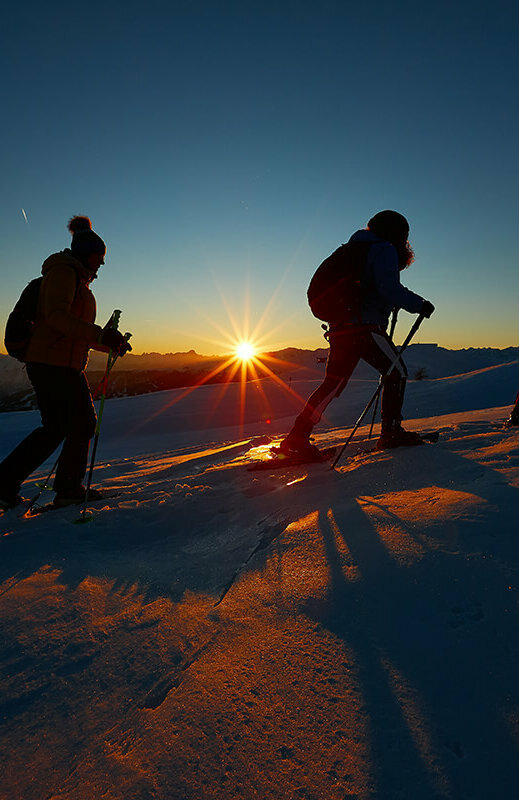Schneeschuhwanderer:innen bei einer Sonnenuntergangswanderung am Zettersfeld