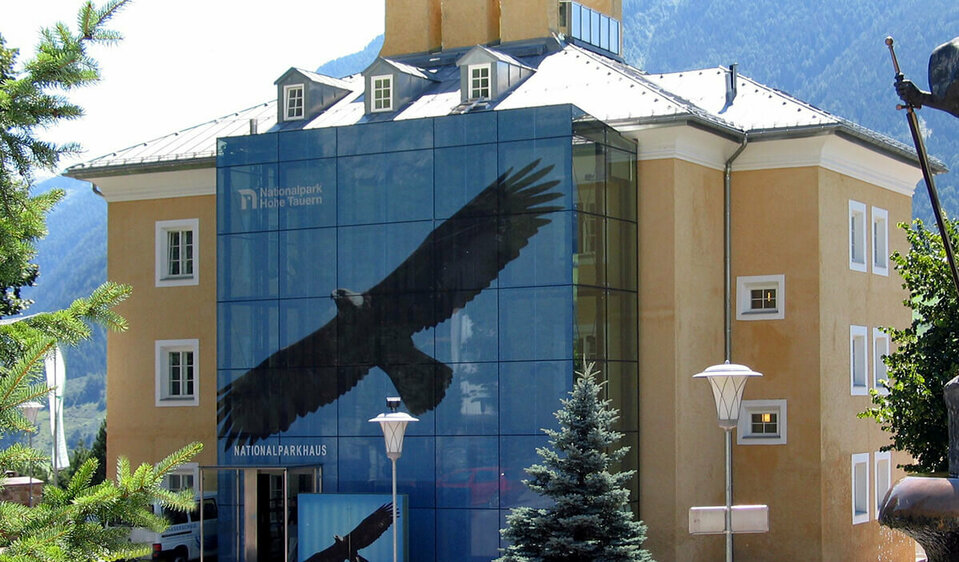 Nationalparkhaus Sommerliche Aussenansicht des Nationalparkhauses in Matrei in Osttirol. An der Glasfassade sieht man einen Bartgeier im Flug