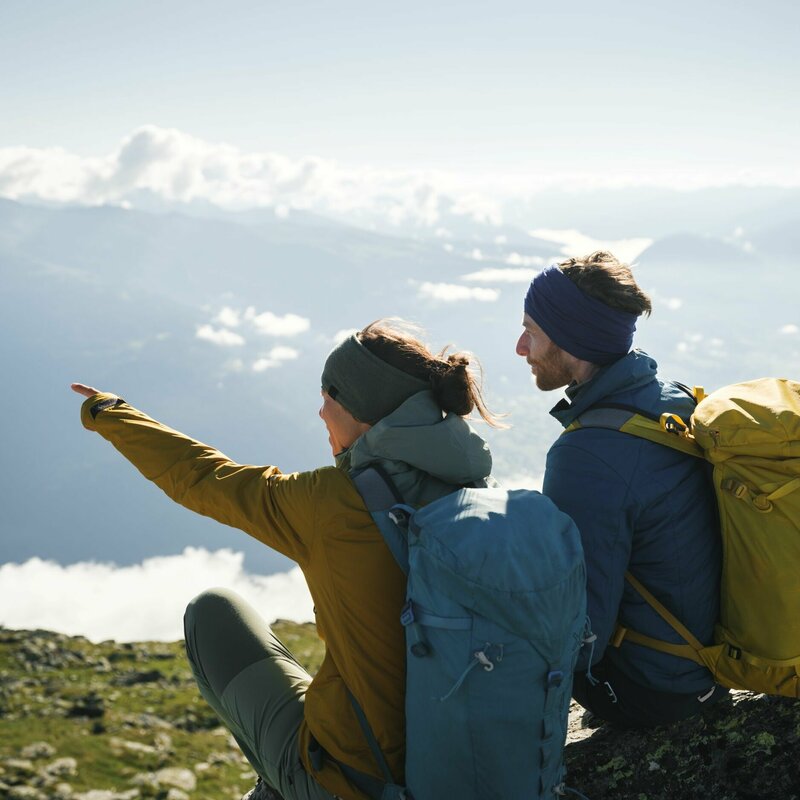 Ein Paar mit Rucksäcken genießt die Aussicht am Bösen Weibele. Die Frau zeigt dem Mann etwas in der Ferne.