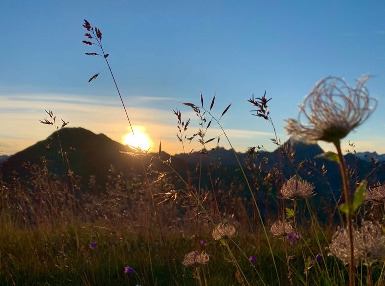 Die Sonne geht hinter den Bergen, die vom Speikboden aus zu sehen sind, langsam auf.
