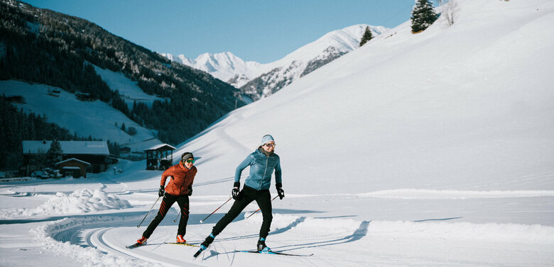 Zwei Langläufer:innen bei perfekten Loipen- und Wetterbedingungen in Innervillgraten.