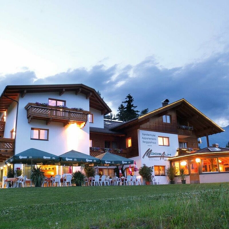 Die beleuchtete Moosalm von außen in der Abendstimmung.