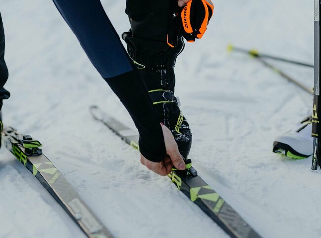 Langläufer Obertilliach Nahaufnahme eines Langläufers beim Justieren seiner Langlaufskier in Obertilliach.