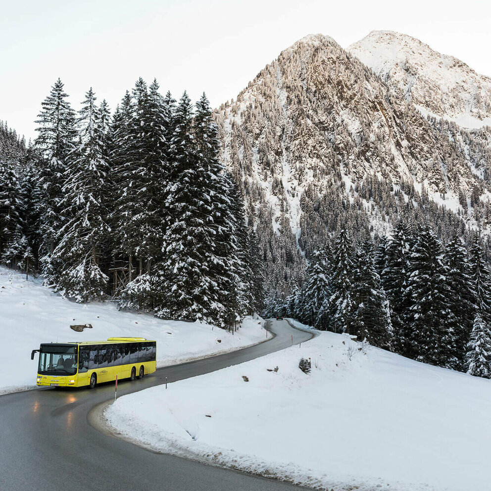 Bus fährt durch verschneite Landschaft