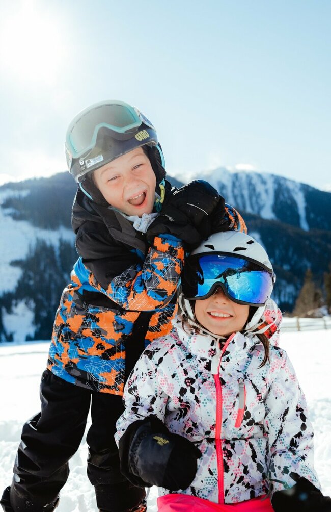 Zwei Kindern haben in der Winterlandschaft in Obertilliach Spaß.