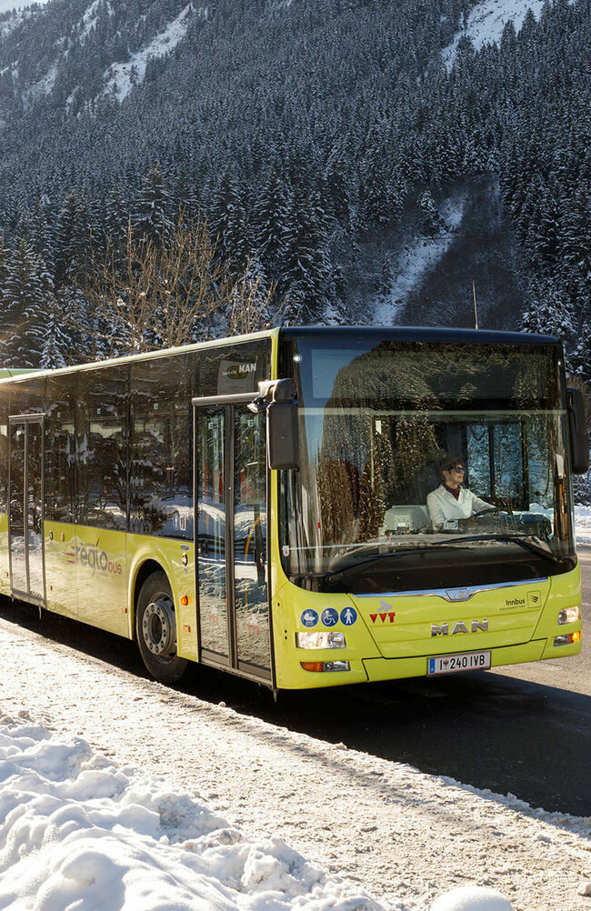 Postbus im Winter Bus inmitten einer Winterlandschaft.