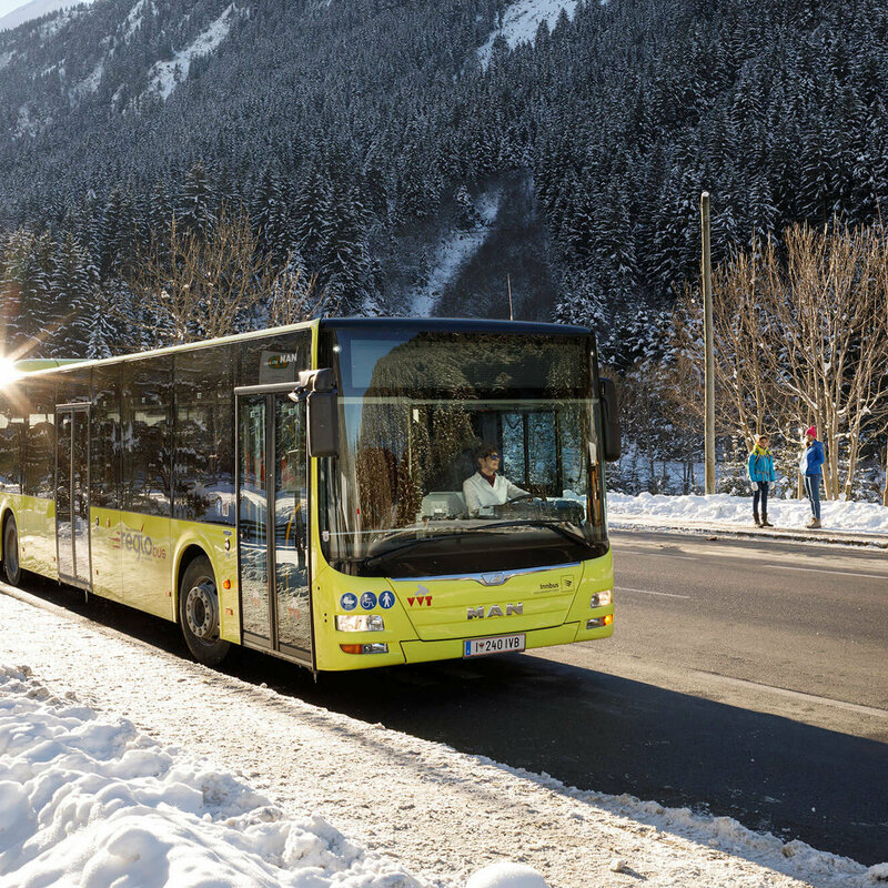 Postbus im Winter Bus inmitten einer Winterlandschaft.