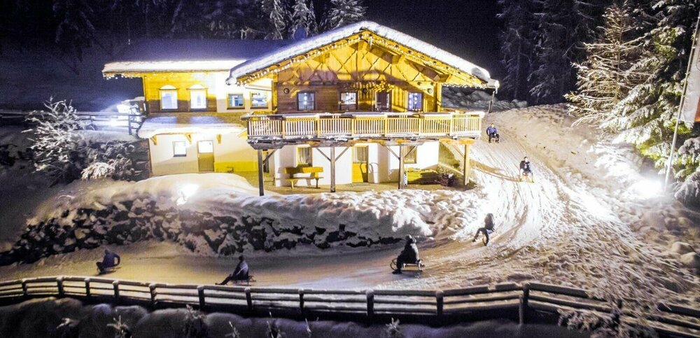 Rodelbahn Würfelehütte Rodelbahn Würfelehütte mit hell erleuchteter Hütte