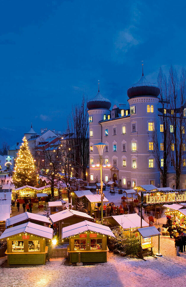 Adventmarkt Lienz Beleuchteter Adventmarkt am Hauptplatz in Lienz in frühabendlicher Stimmung.