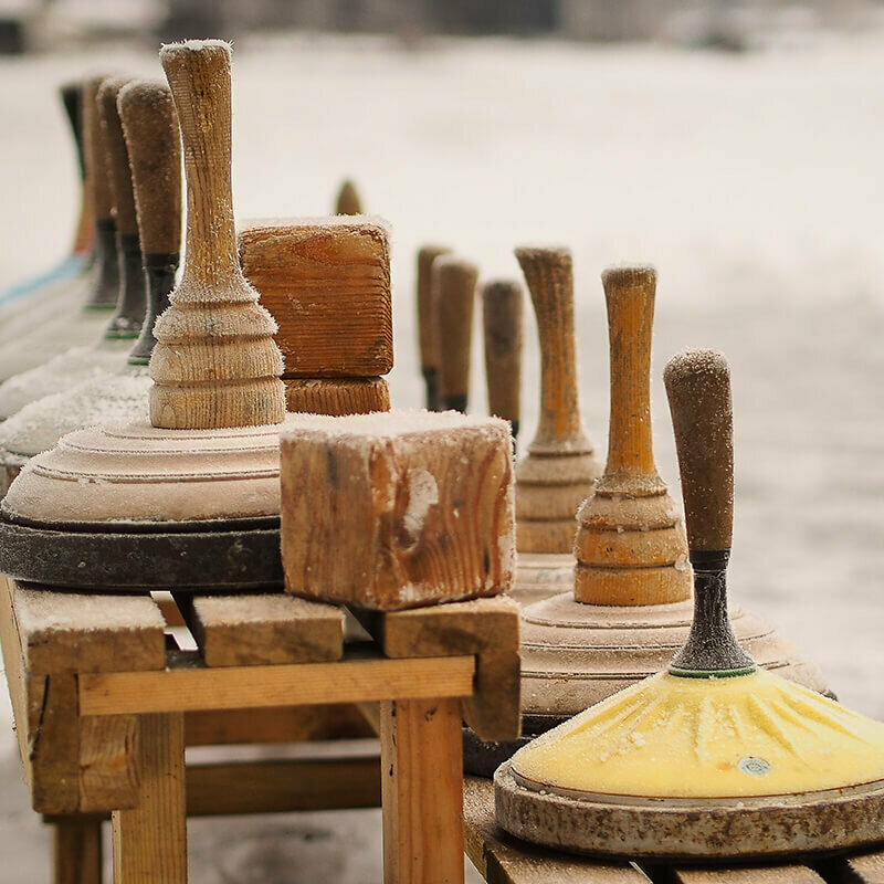 Eisstock Eine hölzerne Bank voll Equipment zum Eisstockschießen.