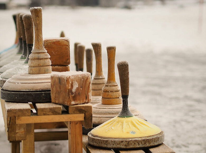 Eine hölzerne Bank voll Equipment zum Eisstockschießen.