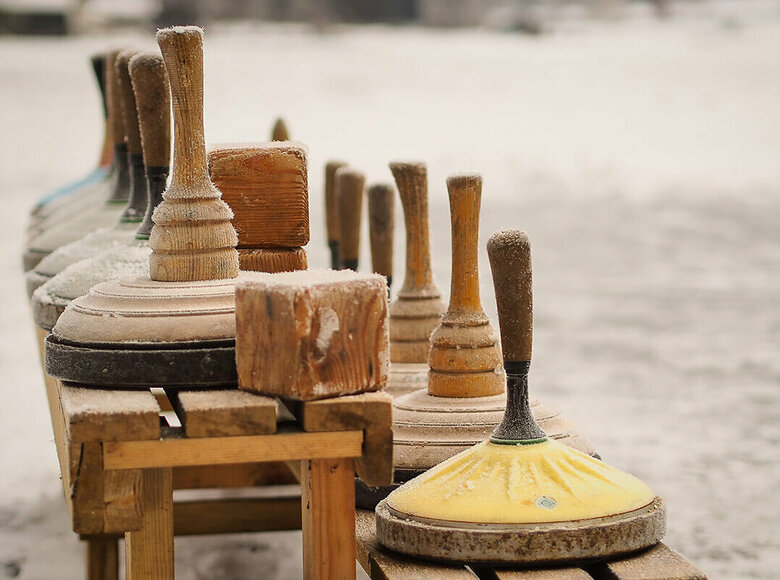 Eisstock Eine hölzerne Bank voll Equipment zum Eisstockschießen.