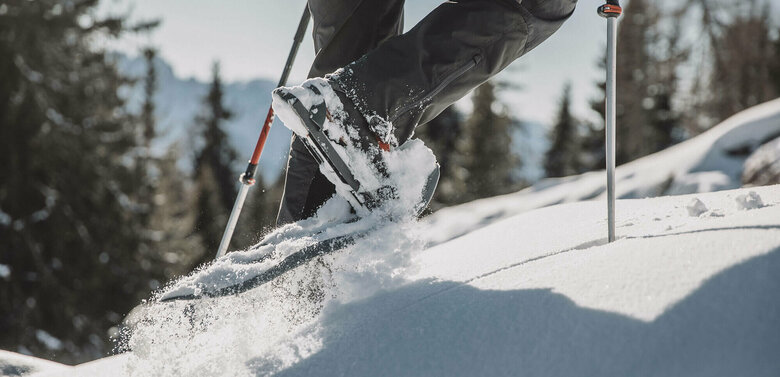 Schneeschuhwandern Die Beine eines Mannes beim Schneeschuhwandern durch den Tiefschnee.