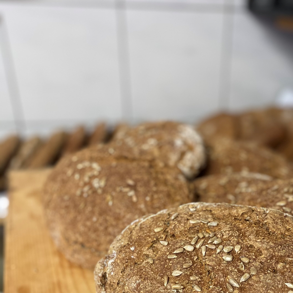 Mehrere Laibe Vollkornbrot mit Körnern.