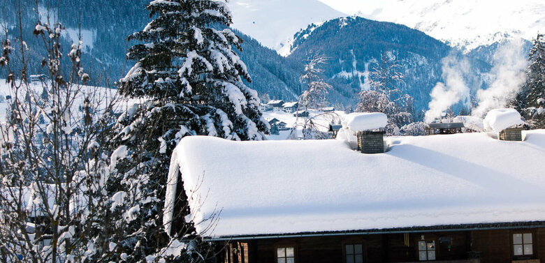 Defereggental Blick auf eine verschneite, dunkle Holzhütte im Winter im Defereggental.