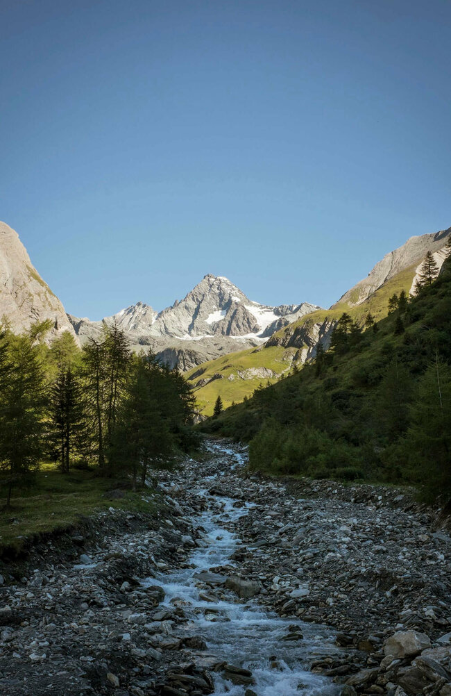 Grossglockner Blick auf einen kleinen Bach mit Grossglockner im Hintergrund an einem herrlichen Tag mit blauem Himmel.