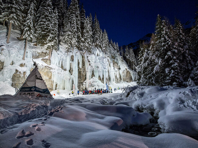 Viele Teilnehmer beim Icefestival Osttirol unterhalb eisbedeckter Felswänden.