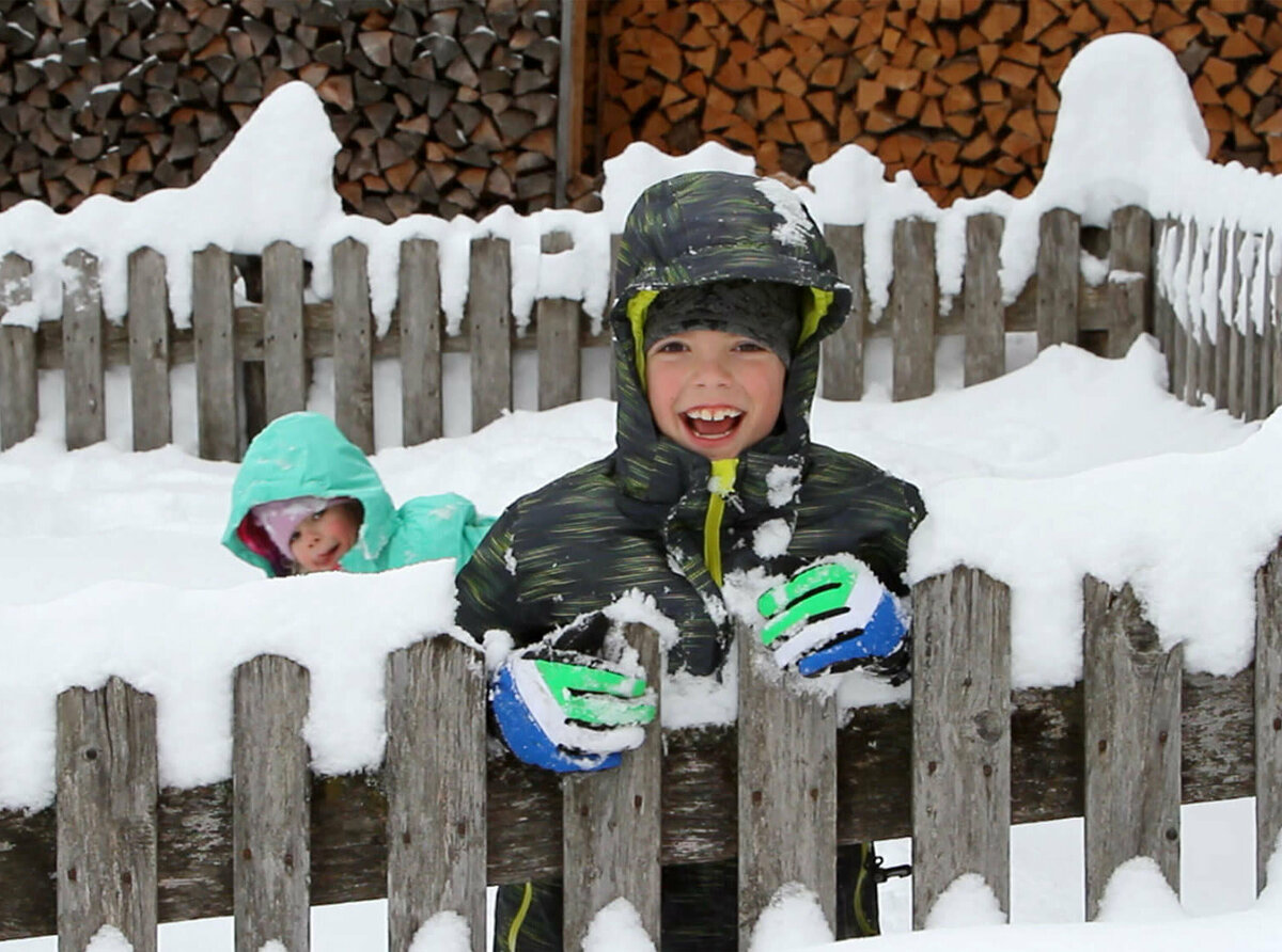 Spielplatz Schnee Zwei Kinder spielen bei Schneefall im frischen Pulverschnee
