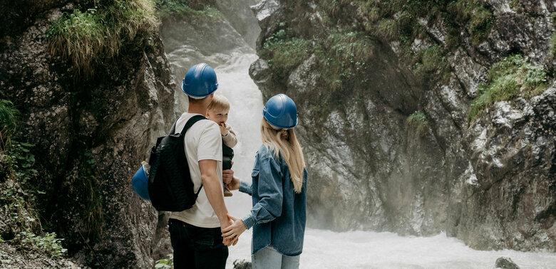 Ein Pärchen mit kleinem Kind auf dem Arm am Wasserschaupfad in der Galitzenklamm.