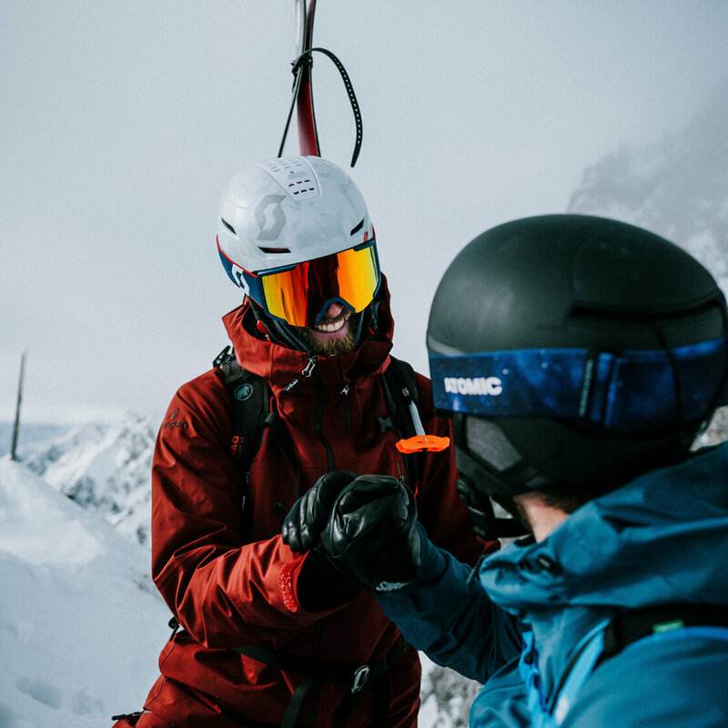 Zwei Skitourengeher sind am Gipfel der Roten Wand im Defereggental in Osttirol angekommen und gratulieren sich gegenseitig zu ihrem Erfolg.