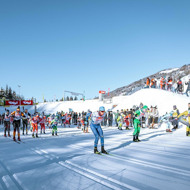 Start beim Dolomitenlauf in Obertilliach - zahlreiche Teilnehmer tummeln sich in den klassischen Spuren der Loipe bei herrlichem Winterwetter.