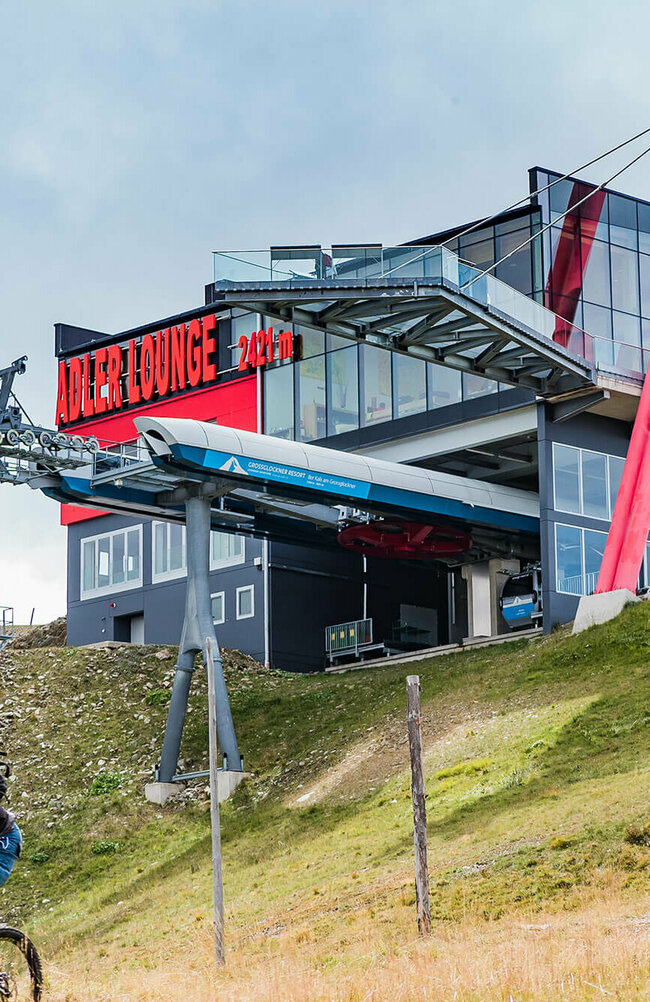 GG Resort Kals Matrei Adler Lounge Zwei talwärts fahrende Mountainbiker unterhalb der Bergstation der Gondelbahn im Großglockner Resort Kals-Matrei