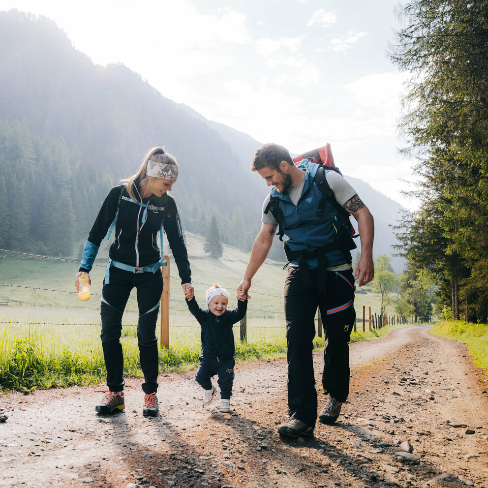 Familienwanderung Kristeinertal Eine Mann und eine Frau mit ihrem kleinen Kind dazwischen wandert im Kristeinertal.
