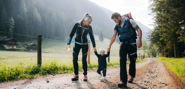 Familienwanderung Kristeinertal Eine Mann und eine Frau mit ihrem kleinen Kind dazwischen wandert im Kristeinertal.
