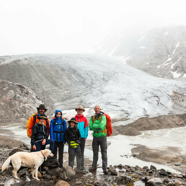 Familie mit Hund bei einer Rangertour im Nationalpark Hohe Tauern bei schlechtem Wetter.