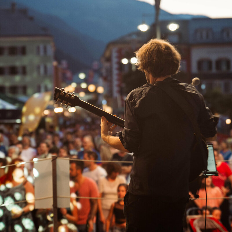 Ein Gitarrist auf der großen Bühne am Hauptplatz beim Sommerfest in Lienz 2024 in Osttirol.