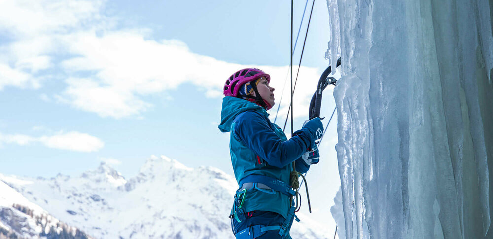 Eiskletterpark Osttirol Eine Person steht am Start einer abenteuerlichen Kletterroute über einen zugefrorenen Wasserfall.