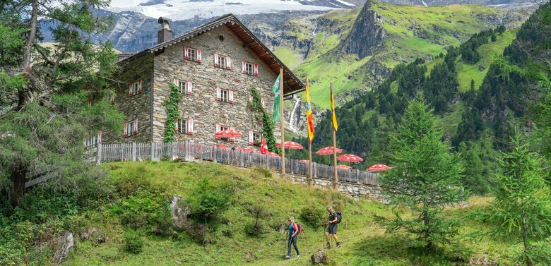 Kalser Tauernhaus Weitwandern auf der Glocknerkrone in Osttirol, Etappe 3: Blick auf das Kalser Tauernhaus, umgeben von Bergen und Natur im Kalser Dorfertal.