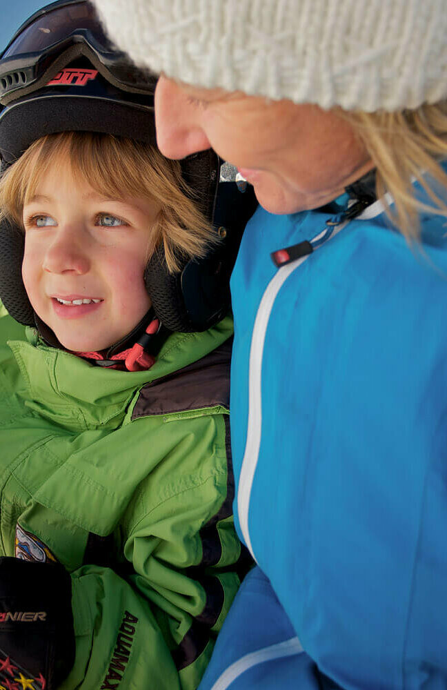 Eine Frau fährt mit ihrem Sohn am Zettersfeld Sessellift