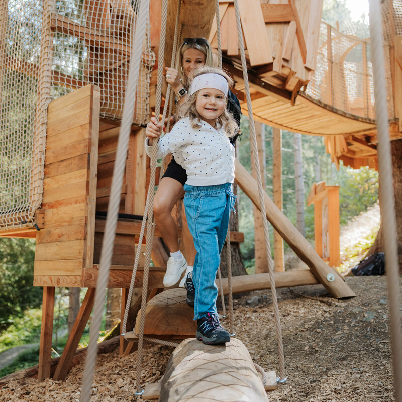 Das Bild zeigt ein Mädchen auf dem hölzernen Klettergerüst im Wichtelpark Sillian.