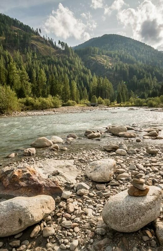 Die Bachaufweitung Schwarzach in Maria Hilf in St. Jakob im Defereggental. Kleiner Steinhaufen am Ufer der Schwarzach.