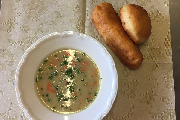 Ein Teller Suppe mit zwei Stück Niggelan daneben.