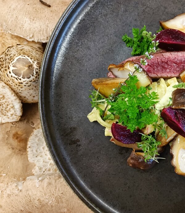 Steak im Moarhof Schwarzer Teller mit Steak und Beilagen im Moarhof.