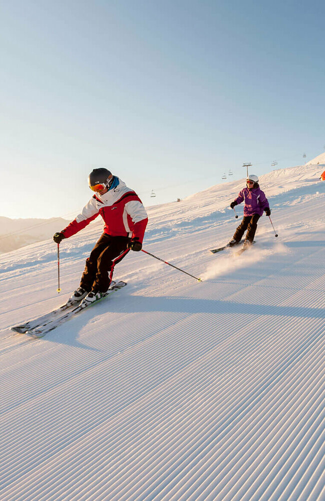 Skifahren Zettersfeld Ein Skilehrer fährt mit mehreren Kindern über eine frisch präparierte Abfahrt im Skigebiet Zettersfeld.