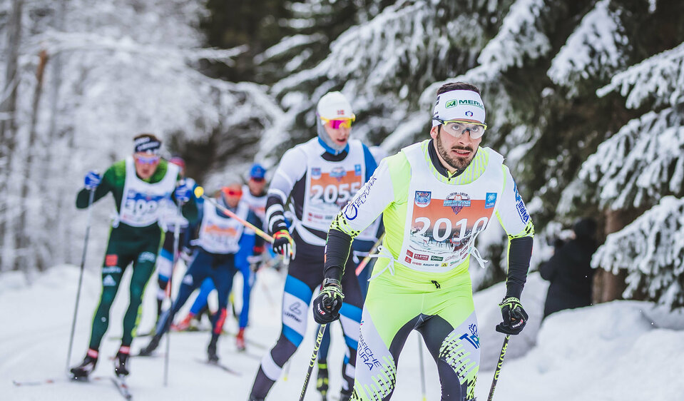 Die Teilnehmer kämpfen auf der Loipe im verschneiten Obertilliacher Wald um den Sieg des Dolomitenlaufes.