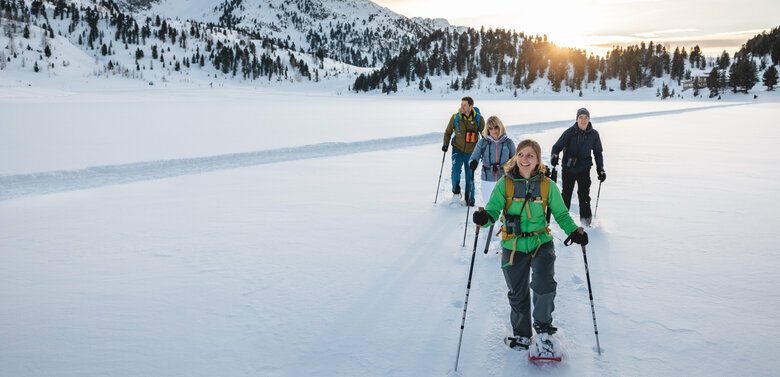 Eine Gruppe Schneeschuhwanderer:innen bei bewölktem Wetter im Nationalpark Hohe Tauern