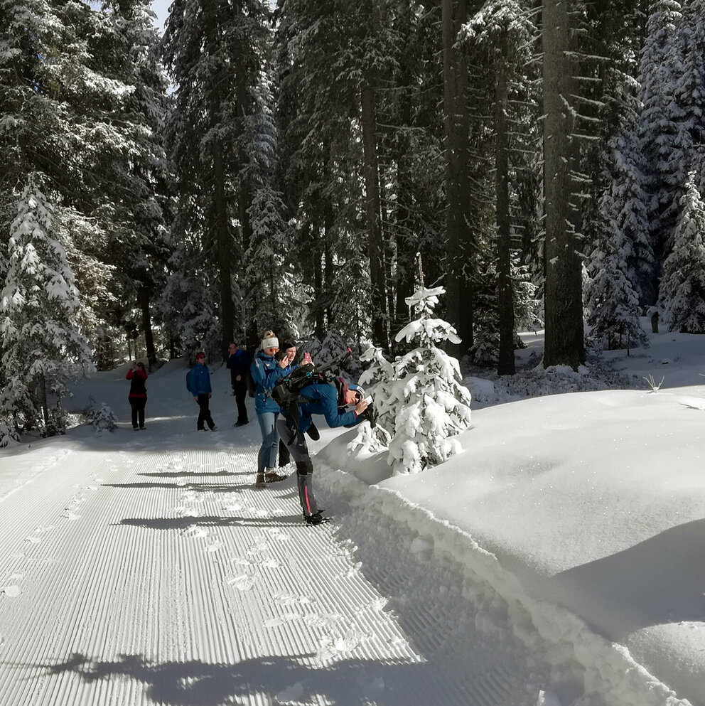 Personen beim Fotografieren des verschneiten Waldes während des Winterwanderns